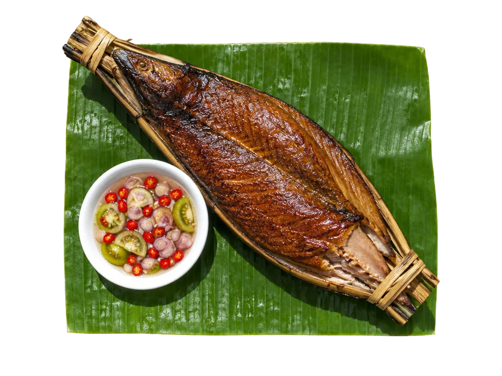 Ikan asar: cakalang asap cokelat mengilap dijepit bambu di atas daun pisang, dengan secawan colo-colo.